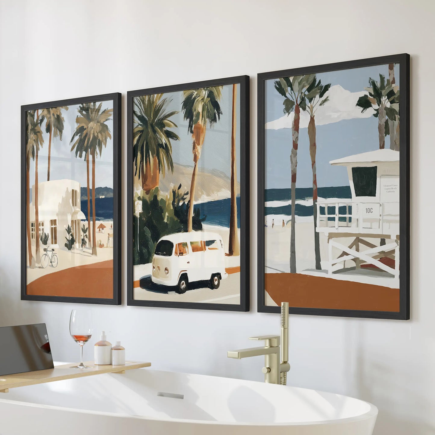 Laguna Beach shoreline wall art trio in black frames brings coastal calm to a bathroom, designed to hang over the tub wall.