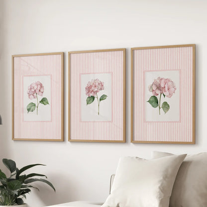 Set of three wall pictures featuring vintage cottage florals in oak frames behind a sofa in a family room.