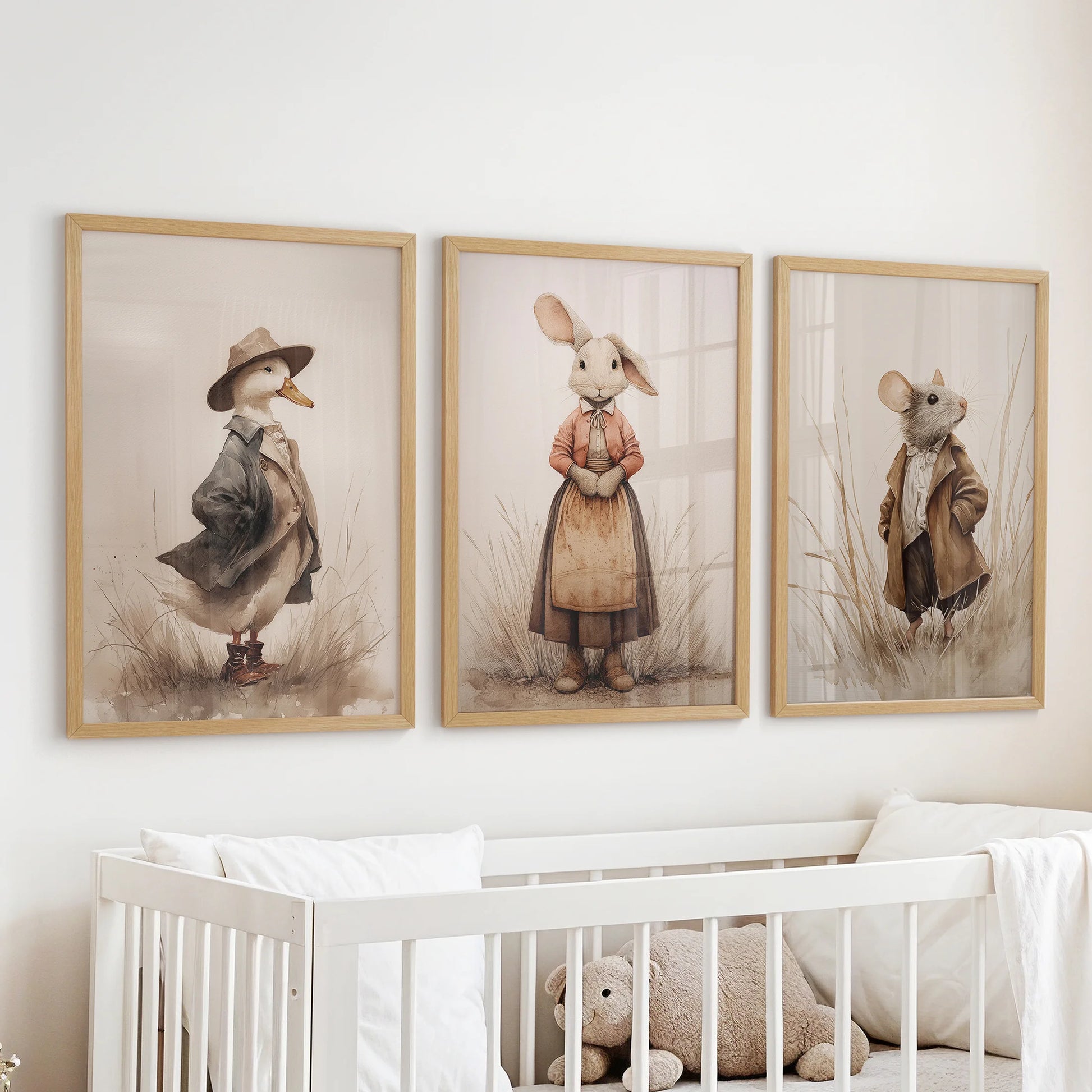 Neutral nursery animal wall art, a three-piece set in wooden frames, hangs above the cot to bring gentle farmhouse warmth and calm, cottagecore texture.