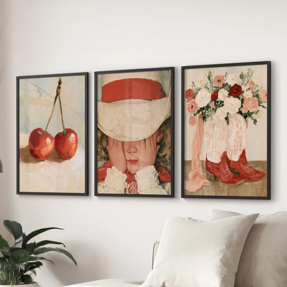 This three-piece wall art set pairs cherries, florals, and a vintage girl in black frames, grounding the family room behind the couch.