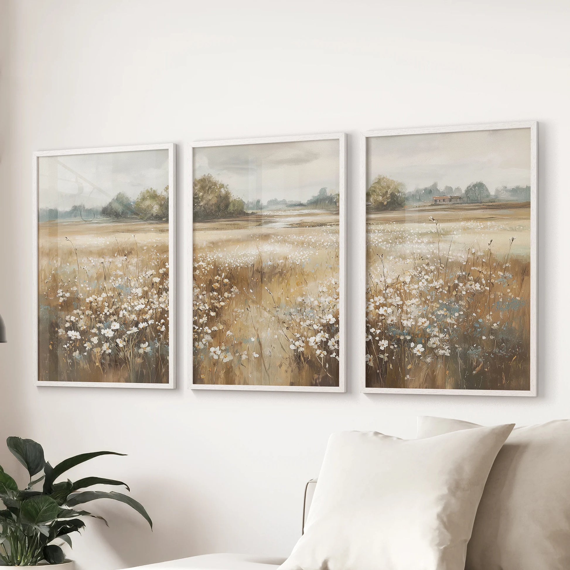 Vintage field scenes wall art, a set of three in white frames, floats above the family-room couch, adding calm country light to the space.