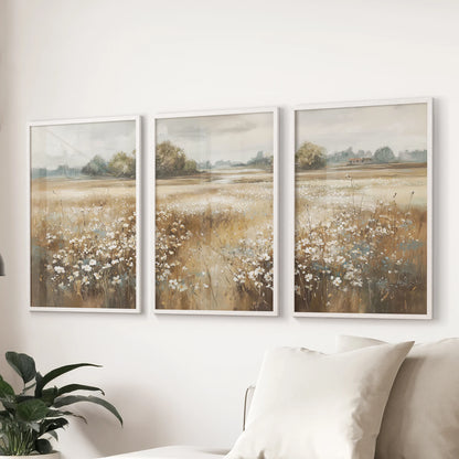 Vintage field scenes wall art, a set of three in white frames, floats above the family-room couch, adding calm country light to the space.