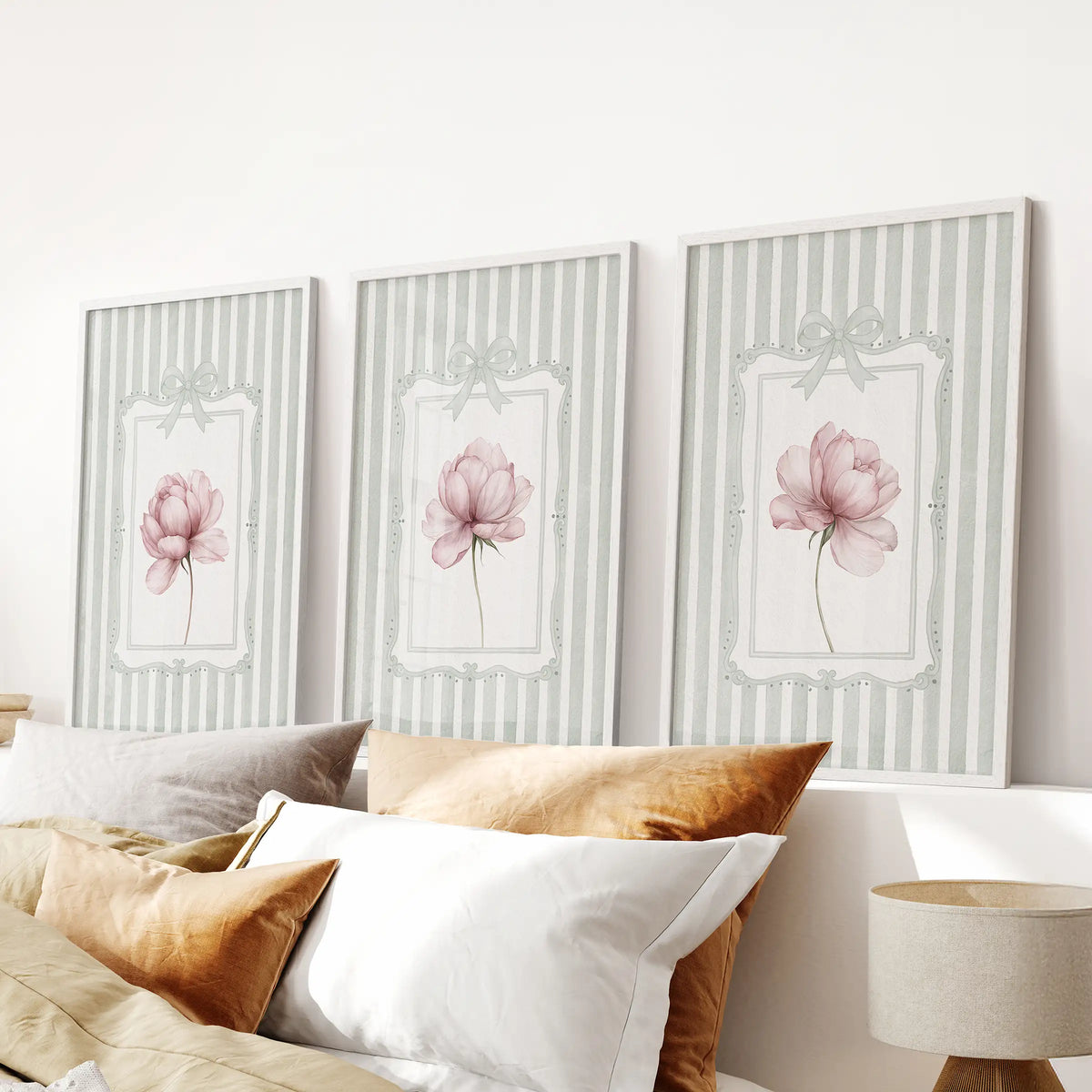 Three-piece peony botanical wall art set in white frames, displayed above a bedroom headboard.
