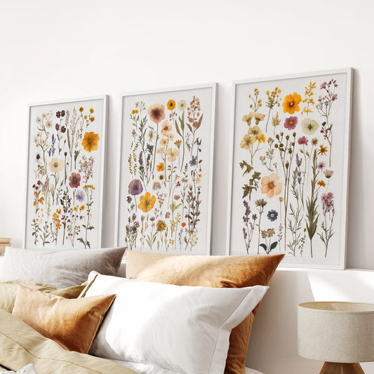 Three vintage floral art prints in crisp white frames line up over the bed headboard for a fresh, refined bedroom accent.