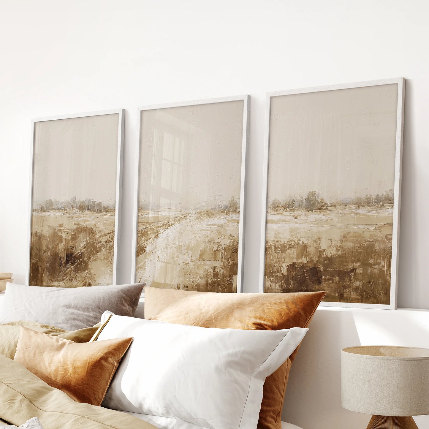 Soft vintage farmhouse landscapes in a three-piece art set with white frames bring quiet texture to the bedroom above the bed.