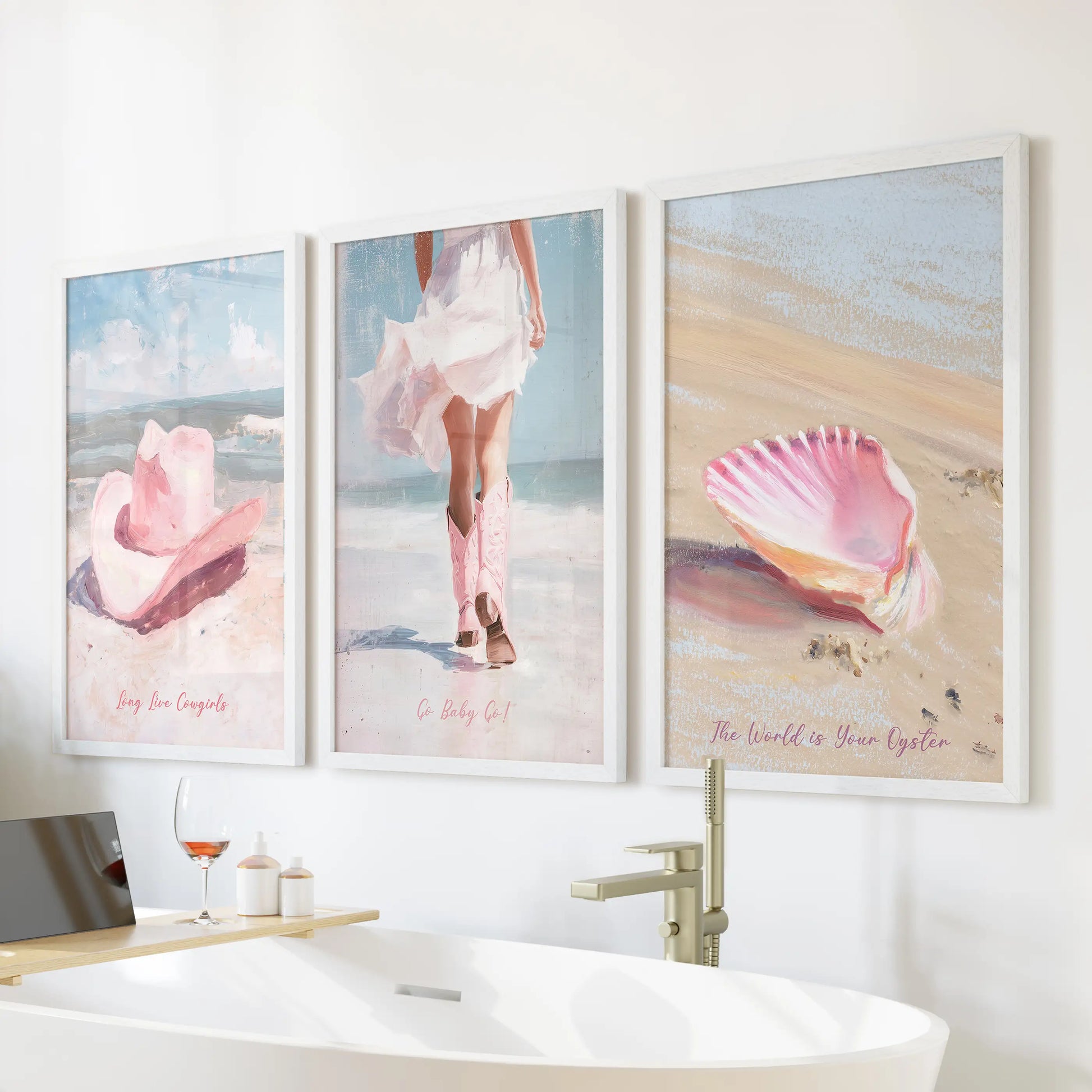 A white-framed wall print trio showing pink cowgirl hats sits over a freestanding tub, bringing soft coastal-western energy to the bathroom.
