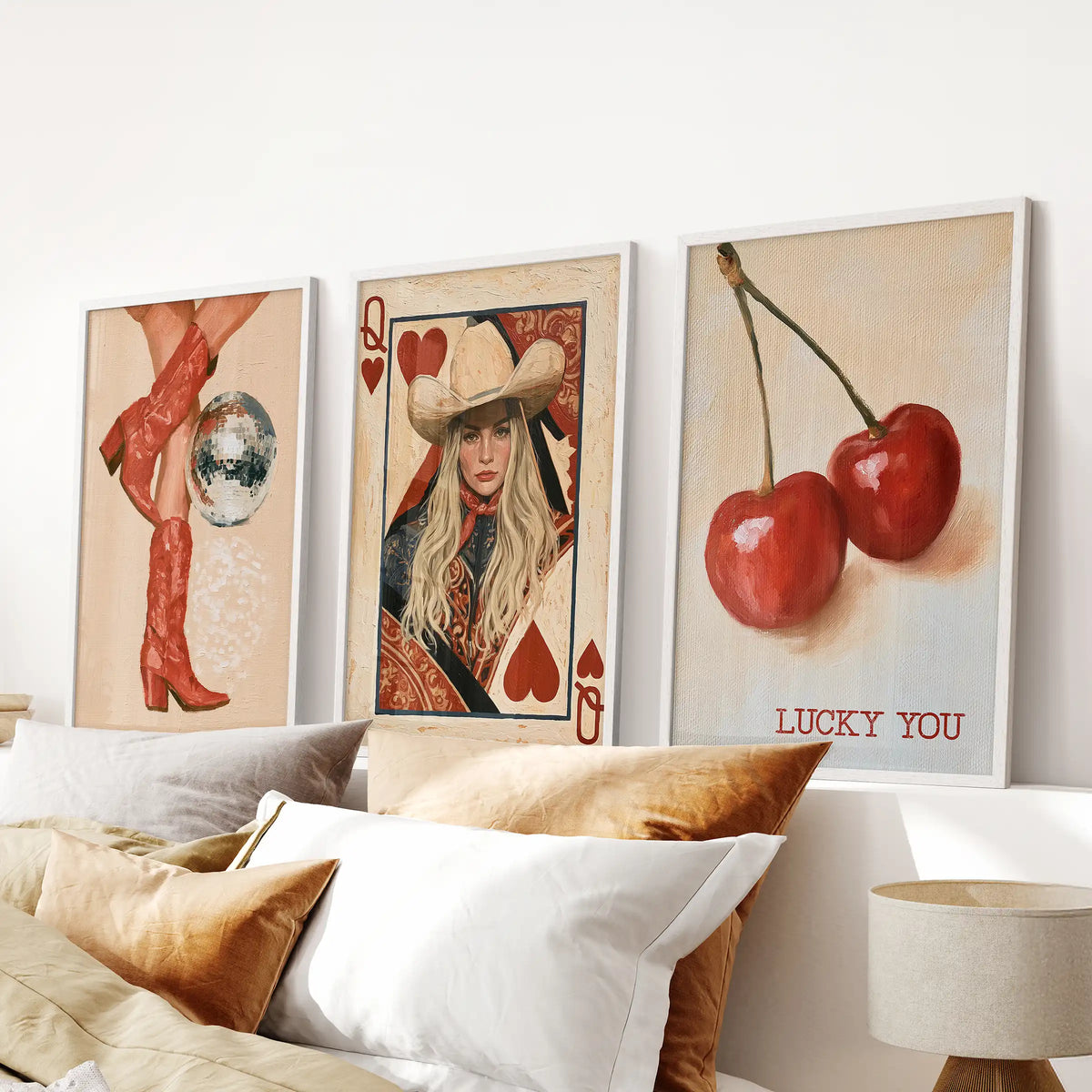 Retro western boots wall art comes as three white-framed prints lined up over the bed, carrying a soft cowgirl theme through the bedroom.