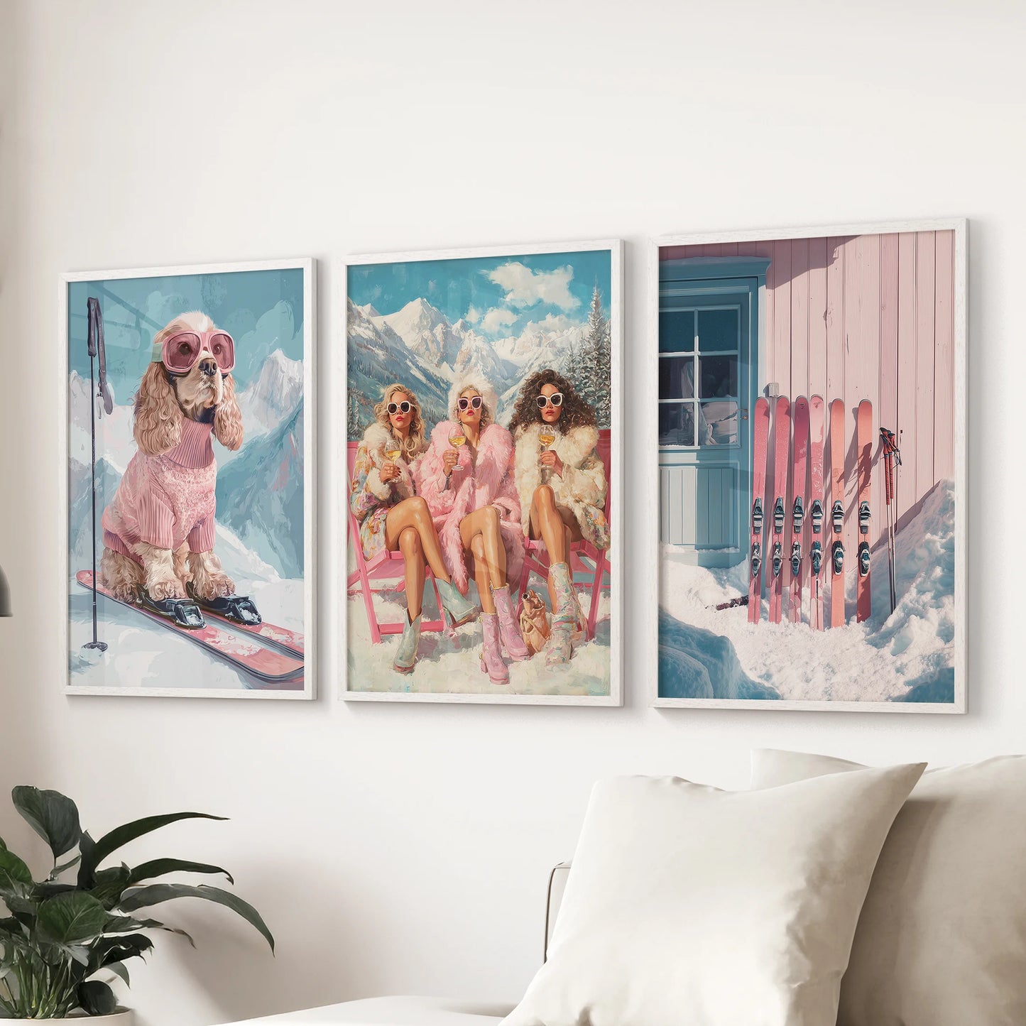 Three framed artworks depicting a dog on skis, women in pink outfits, and pink skis against a cabin.