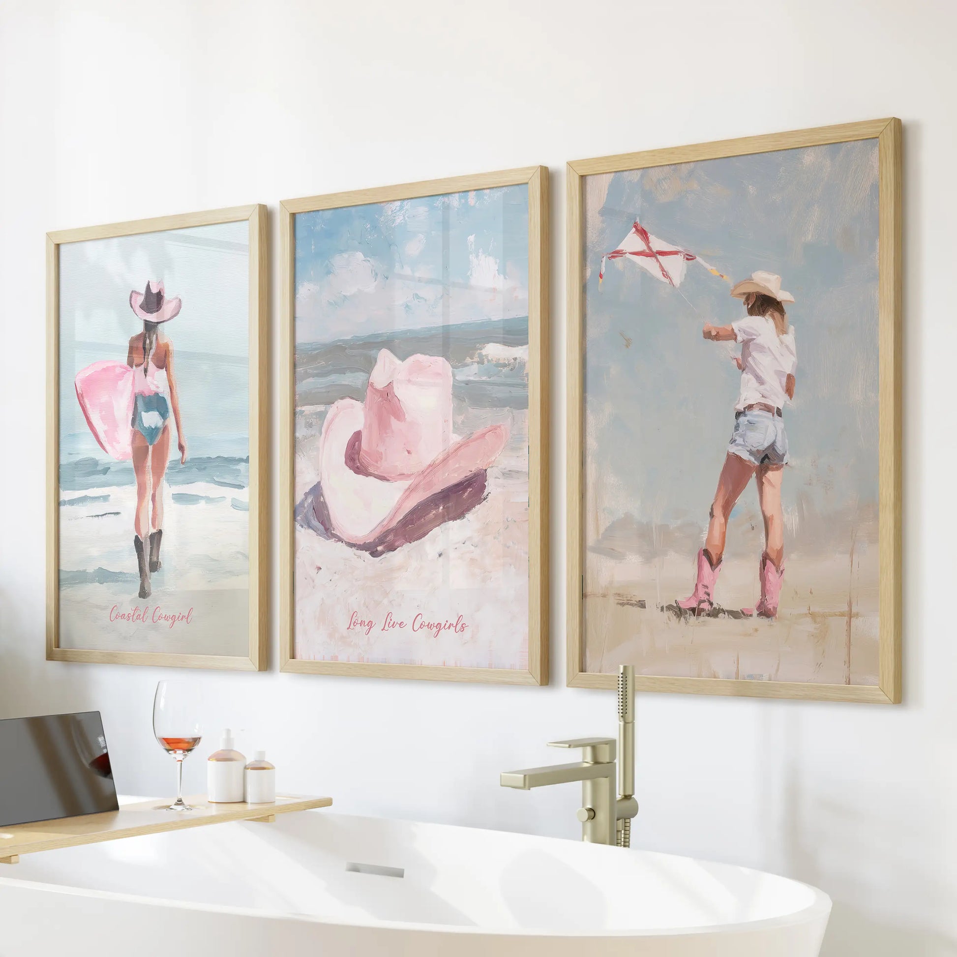 Preppy pink beach art 3-piece set of wall prints with thin wood frames lines the bathroom's tub wall, bringing light surf vibes to a serene space.