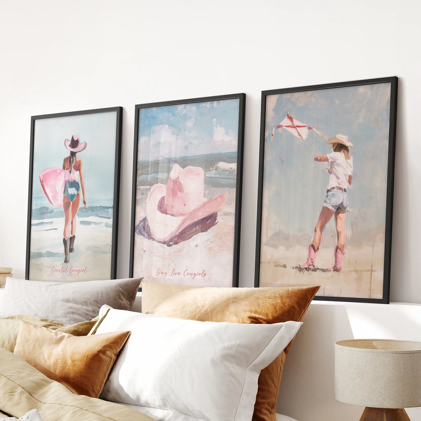 Vintage western cowgirl wall hanging set of three art prints in matte black frames, riding high over the headboard to anchor a softly pink bedroom.
