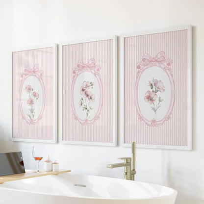 Vintage wildflower botanicals in a gallery wall set of three, white framed and displayed above the bathtub wall in a bathroom.