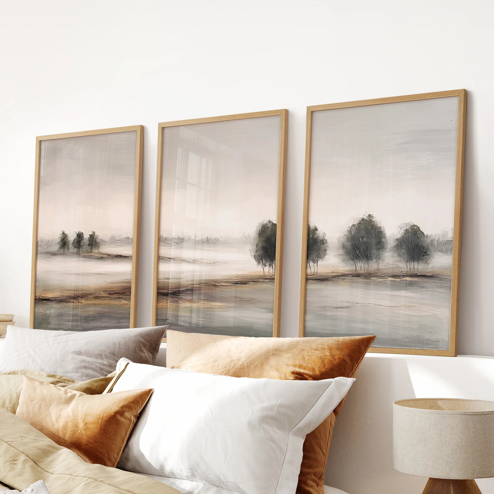 Farmhouse country landscape set, a 3-piece print suite in light wood frames, hangs above the headboard to warm the bedroom with sunlit neutral fields.