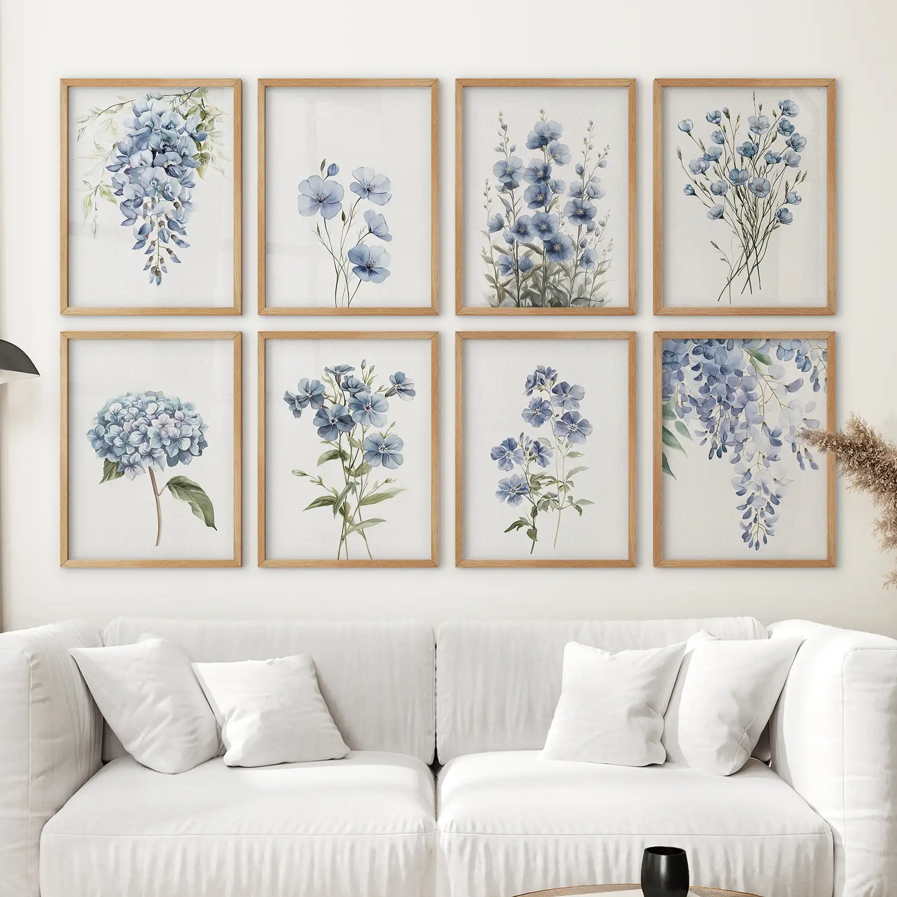 Set of 8 blue floral watercolor prints featuring wisteria, hydrangea, pansy, and delphinium flowers. Thinwood frames over the couch.