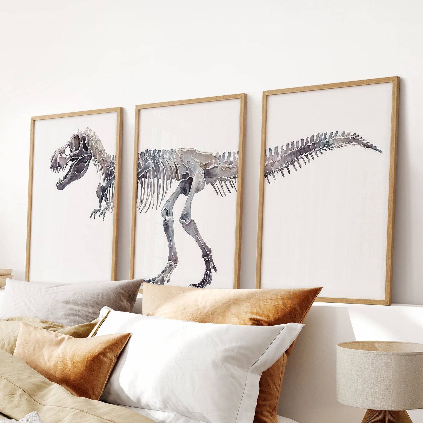Dino fossils prints, three-piece wall art, arranged over the bed's headboard in light wood frames for a soft, modern bedroom accent.