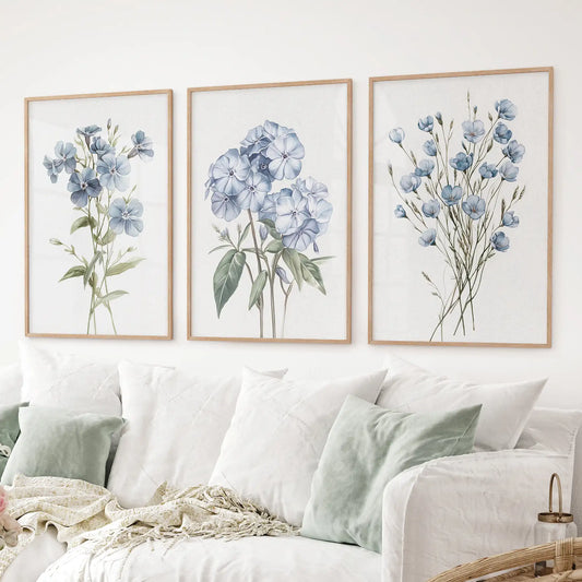 Minimalist botanical artwork with soft wildflowers in blue colors. Thinwood frames over the couch.
