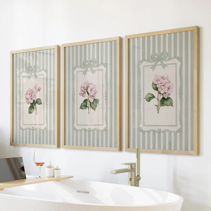 Garden flowers in a set of three wall art prints hang over a bathroom bathtub, with each print presented in a wood frame.