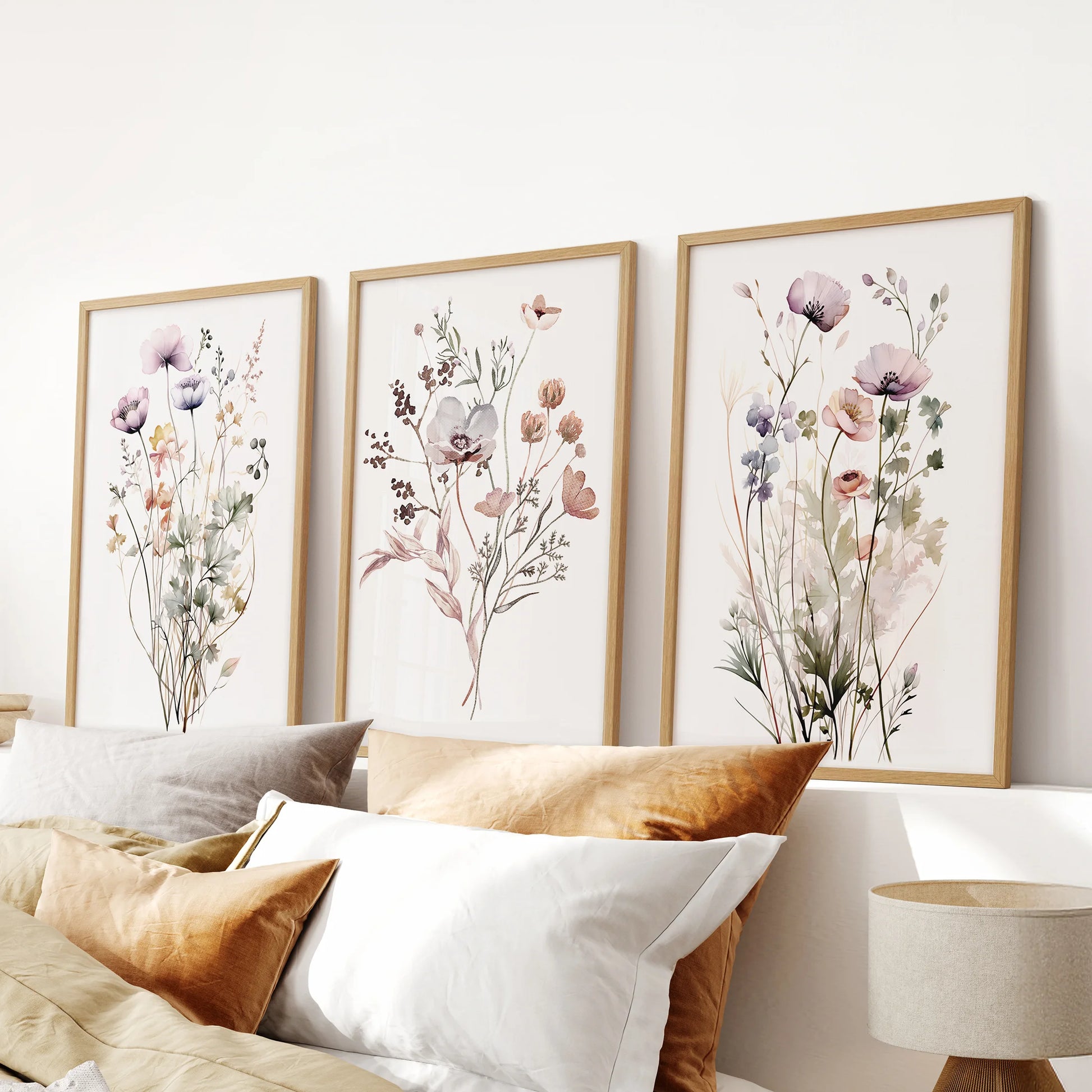 Wildflower meadow wall art set of three, wood framed prints arranged over the bed headboard for a calm, nature-led bedroom accent.