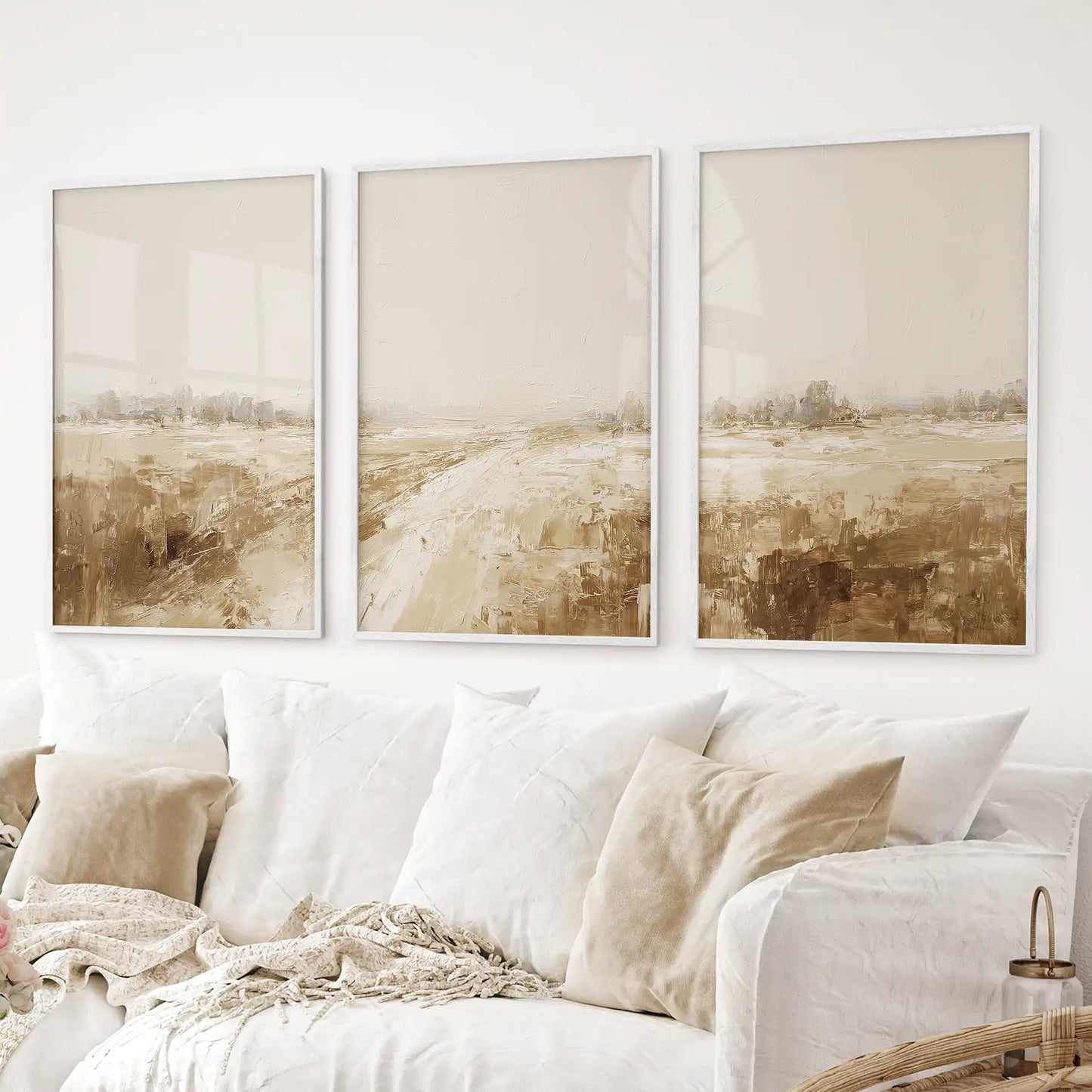 Minimalist 3 piece beige landscape wall art set with textured brushstrokes and soft neutral tones. White frames above the sofa.