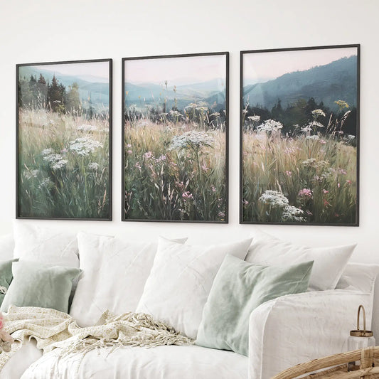 Botanical field painting prints with distant blue mountains and blooming wildflowers. Black frames for living room.