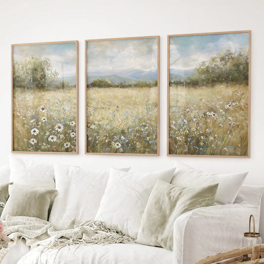 Wildflower meadow wall art set of 3 with daisies and mountains. Thinwood frames over the couch.