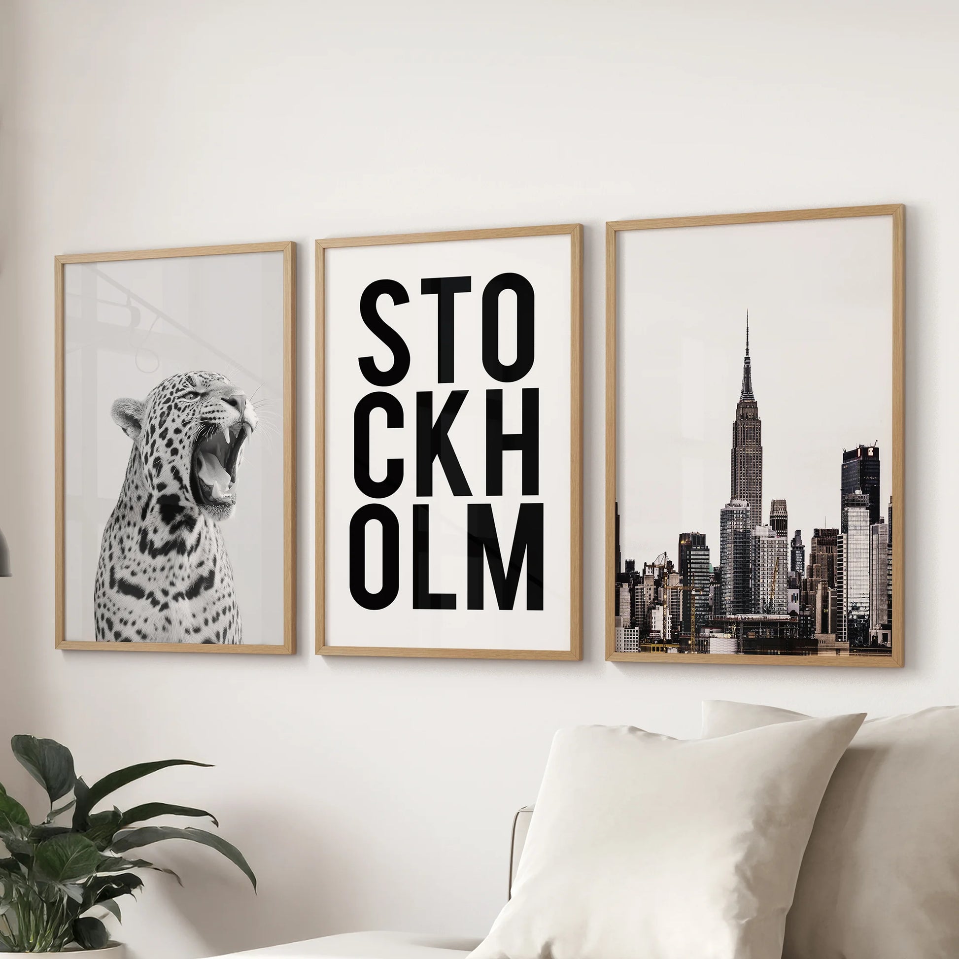Black and white leopard art, a three-poster bundle in warm oak frames, styled behind the sitting-room sofa for an easy, y2k-tinged focal wall.