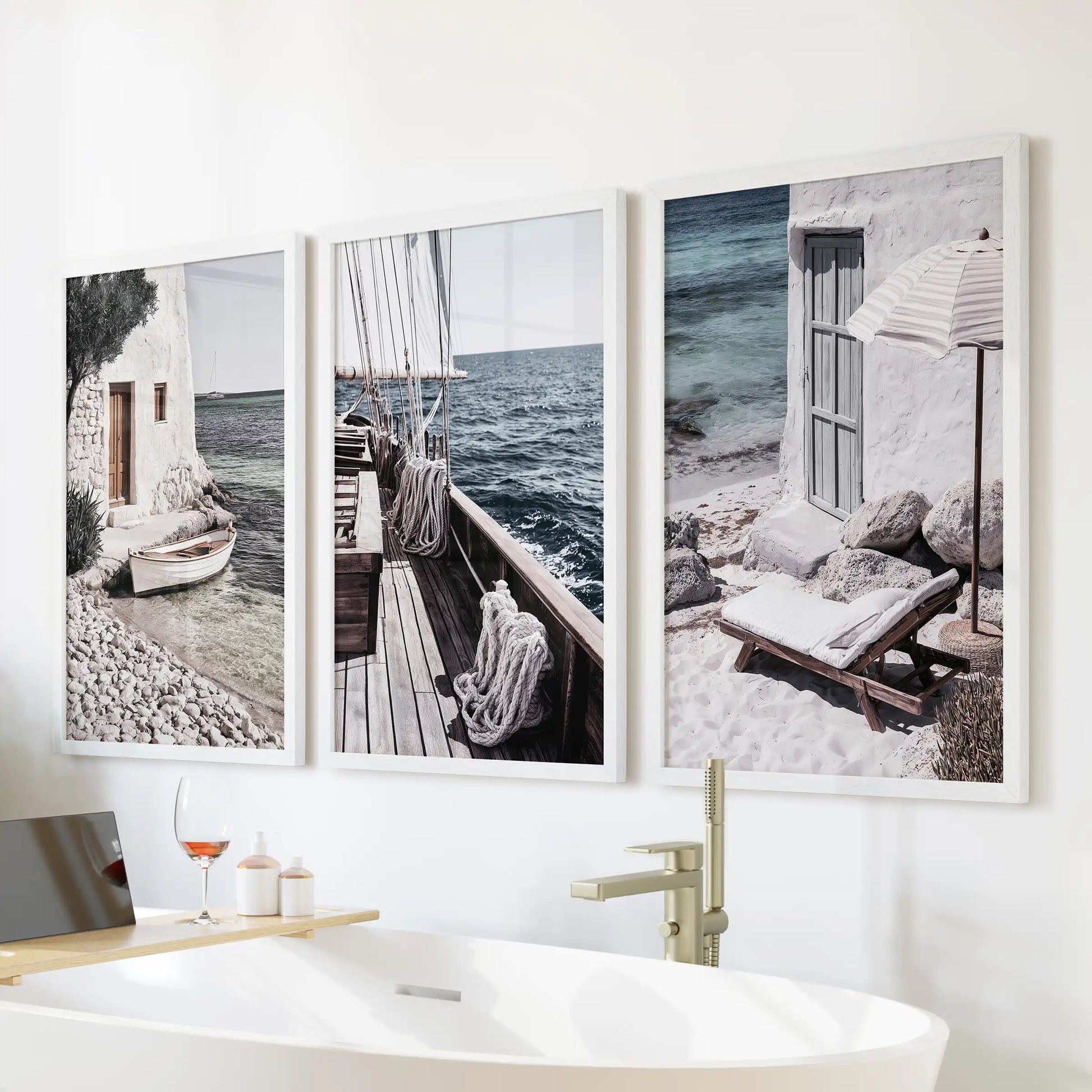 Mediterranean sailboats, a set of 3 wall prints in white frames, placed above the tub to lend a light sea-breeze feel to the bathroom.